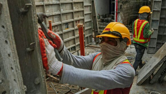 Worker installing steel formwork