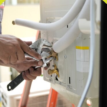 Technician connecting refrigerant pipes