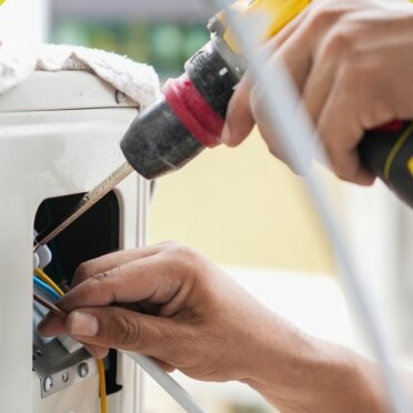 Technician wiring an air conditioning unit