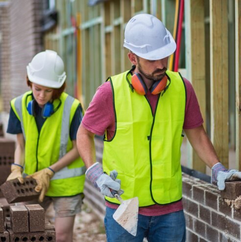 Helpers assisting with blockwork