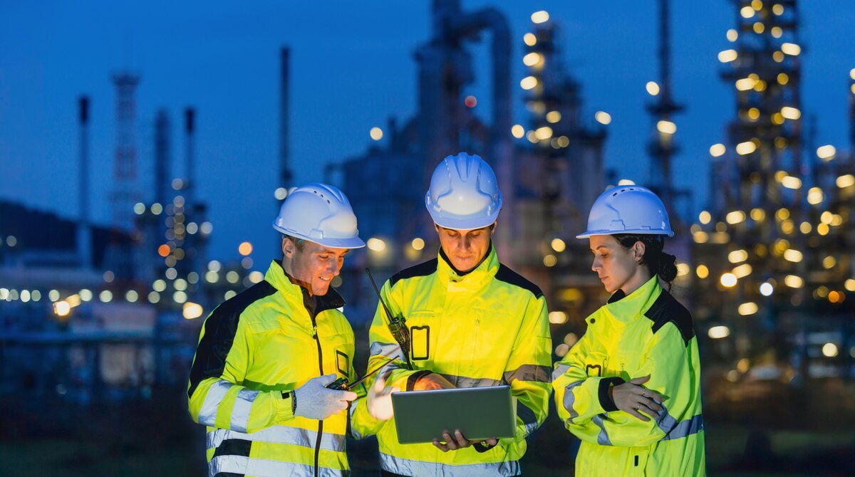 Oil and gas technicians at a refinery at night