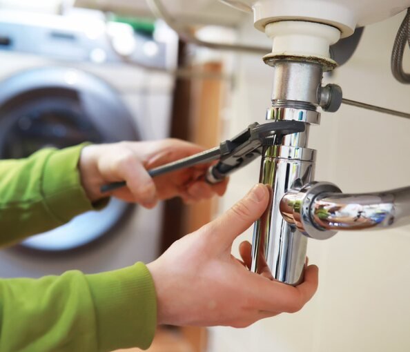 Plumber fixing a sink trap