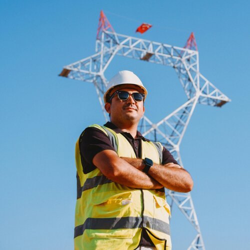 Engineer in front of a transmission tower